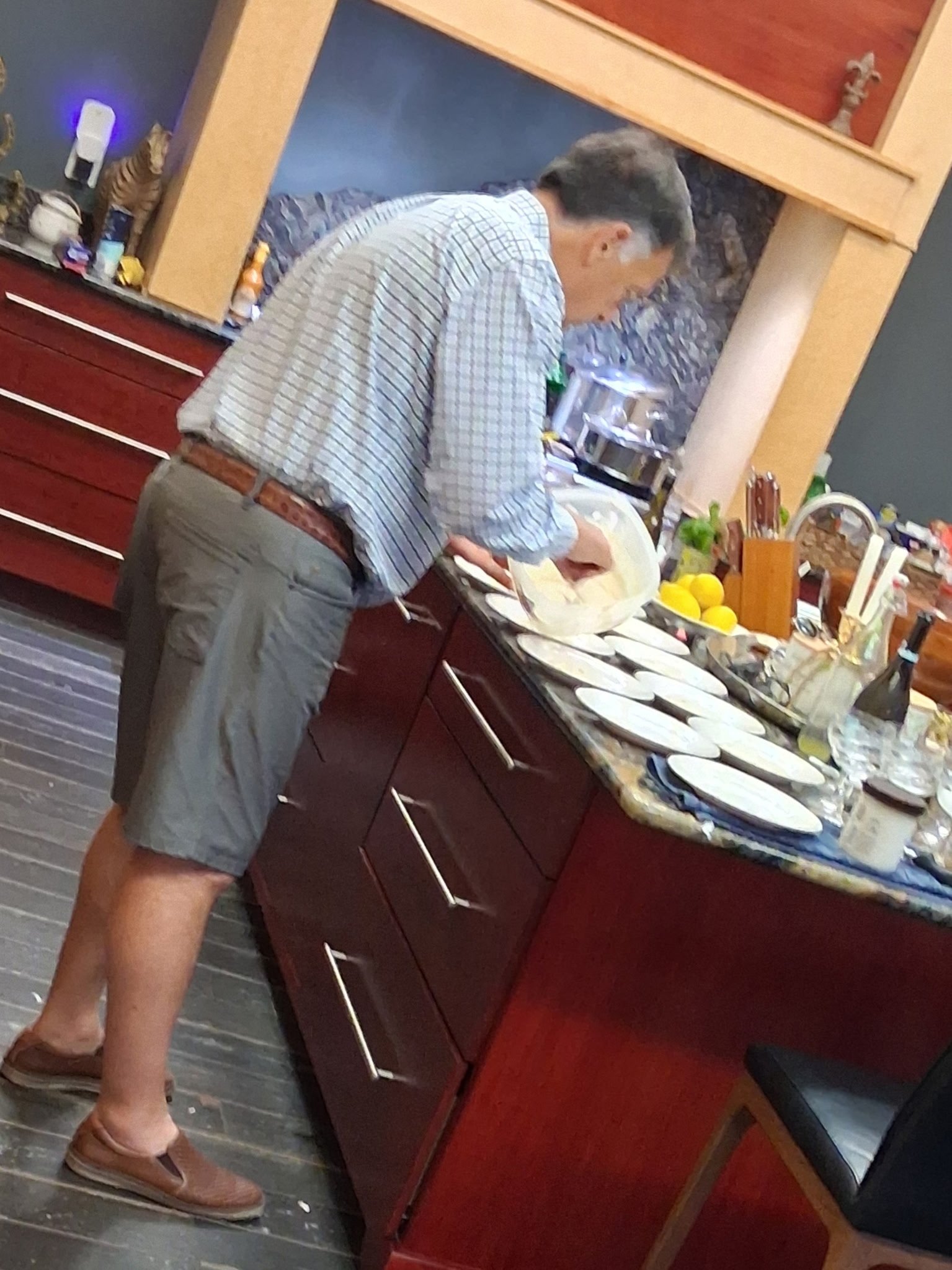 Event staff carefully plating dishes at a kitchen island before service