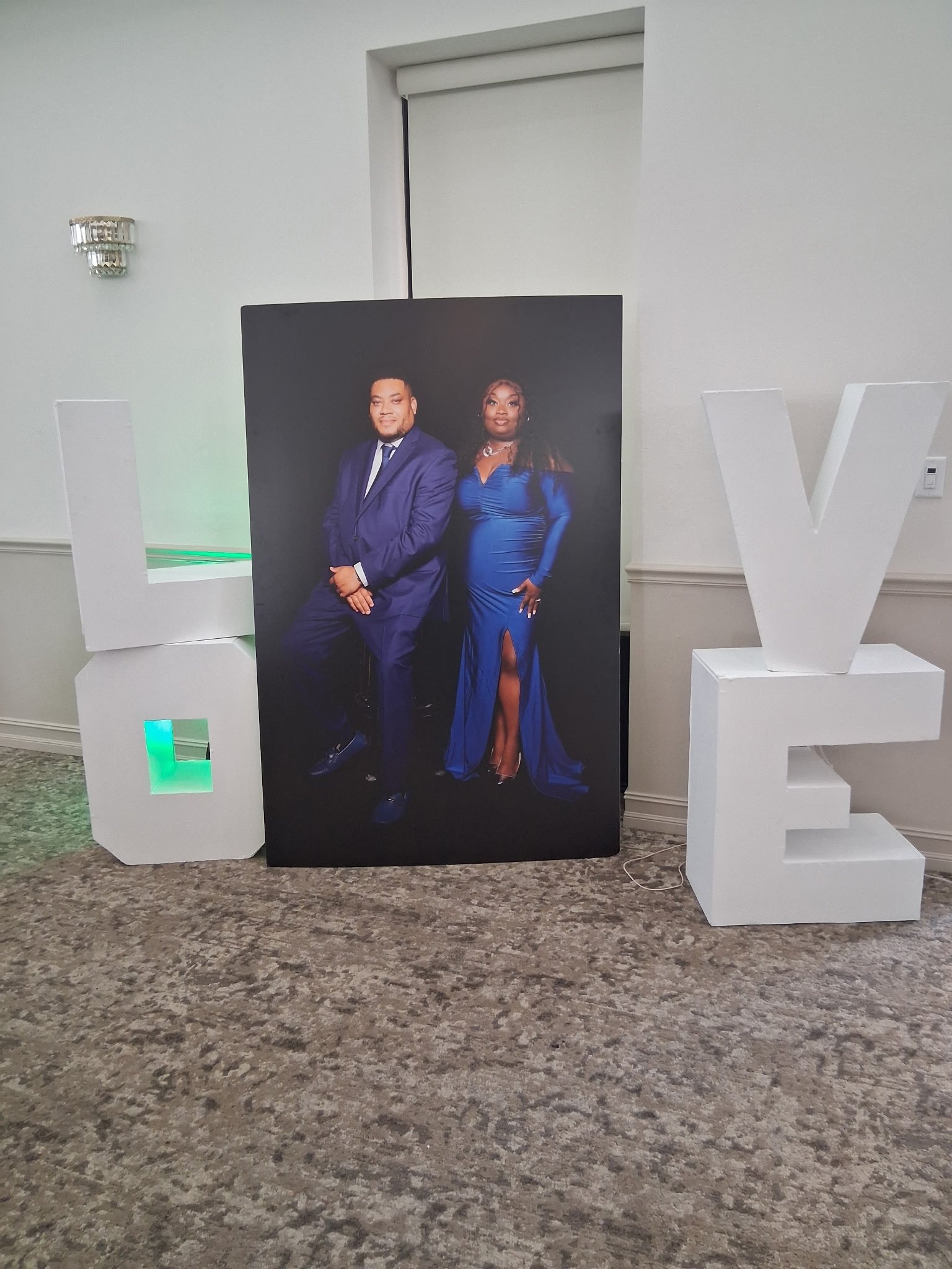 Framed wedding portrait flanked by oversized white LOVE letters